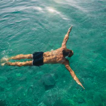 Mann schwimmt im Achensee