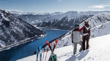 Paar mit Kurzski blickt auf Achensee