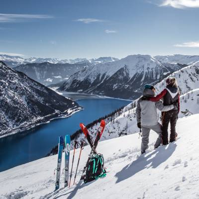 Paar mit Kurzski blickt auf Achensee