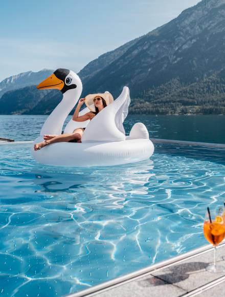 Frau auf aufblasbarem Schwan im Pool