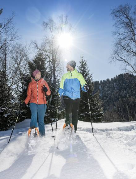 Paar beim Schneeschuhwandern im Winterurlaub