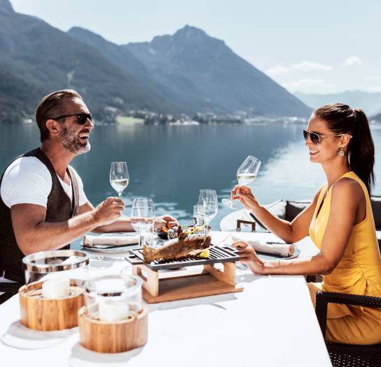 Paar beim Essen mit Weißwein am Achensee