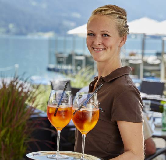 Kellnerin in Entners Strandbar serviert Aperol Spritz