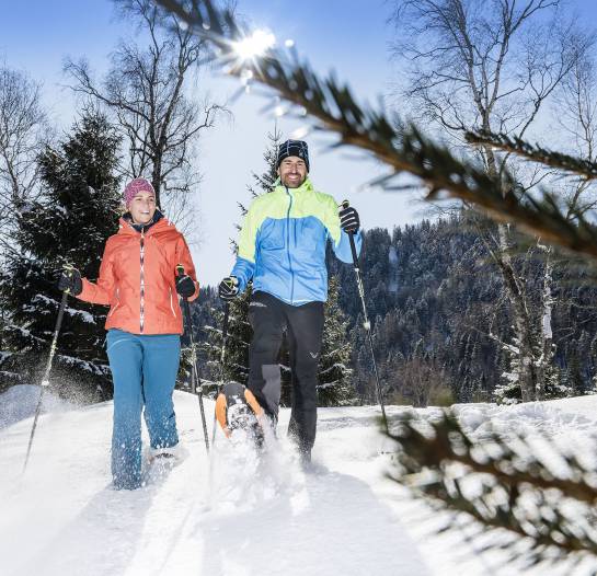 Paar beim Schneeschuhwandern im Winterurlaub